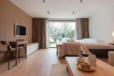 a bedroom with a bed and a living room with a desk at Studio Campo in Bentveld