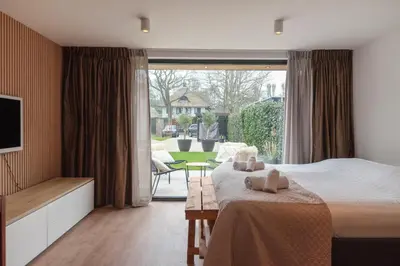 a bedroom with a bed and a large window at Studio Campo in Bentveld