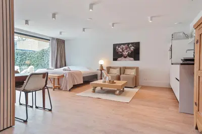 a bedroom with a bed and a living room with a table at Studio Campo in Bentveld