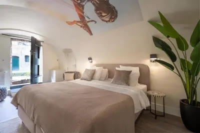 a bedroom with a large bed and a potted plant at Court Hotel Utrecht City Centre in Utrecht