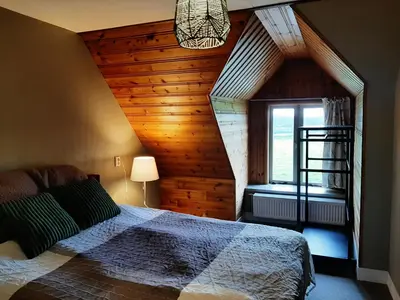 a bedroom with a bed and a wooden wall at Appartement Voorhuis en chalet Klein Waterland in Amsterdam