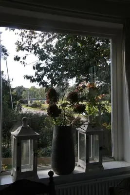 a window with a vase with flowers in it at Appartement Voorhuis en chalet Klein Waterland in Amsterdam