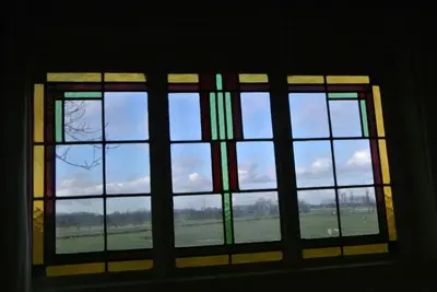 a stained glass window with a view of a field at Appartement Voorhuis en chalet Klein Waterland in Amsterdam