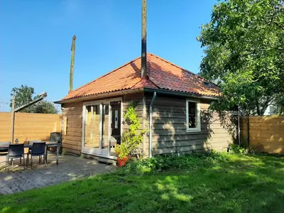a small house with a table and chairs in a yard at Appartement Voorhuis en chalet Klein Waterland in Amsterdam