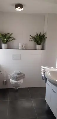 a white bathroom with a toilet and a sink at Appartement Marigold in Zandvoort