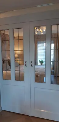 a white cabinet with glass doors in a room at Appartement Marigold in Zandvoort