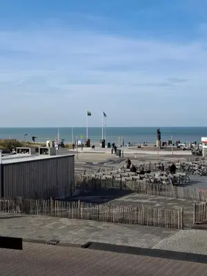 a beach with tables and chairs and the ocean at Appartement Marigold in Zandvoort
