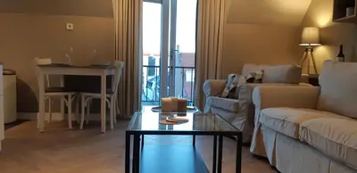a living room with a couch and a table at Appartement Marigold in Zandvoort