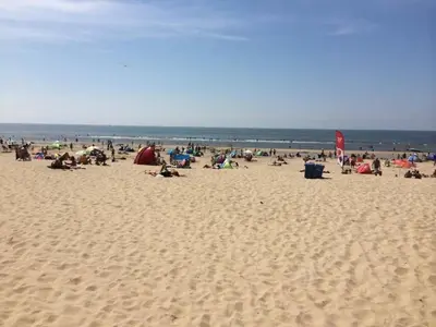 a group of people sitting on a beach at Gestrand in Egmond aan Zee