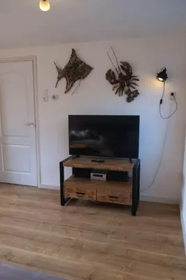 a living room with a flat screen tv on a table at Gestrand in Egmond aan Zee