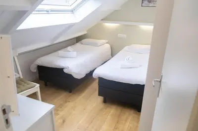 two beds in a small room with a skylight at Gestrand in Egmond aan Zee
