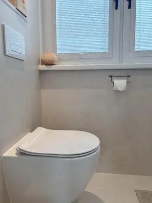 a white toilet in a bathroom with two windows at Studio No3 in Katwijk aan Zee