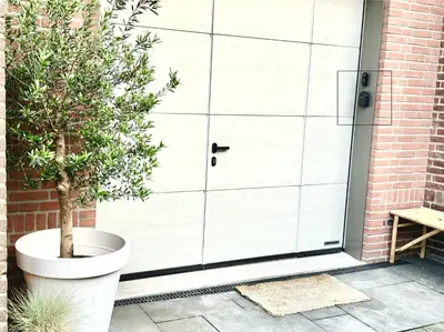 a door with a tree in a pot next to a building at Studio No3 in Katwijk aan Zee