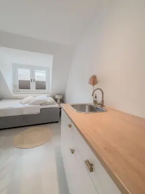 a bathroom with a sink and a bedroom with a bed at Studio No3 in Katwijk aan Zee