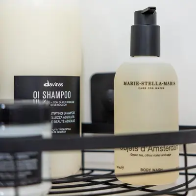a bottle of oil shampoo sitting on a shelf at Boat suite - A Unique Houseboat Stay in Amsterdam in Amsterdam