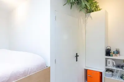 a bedroom with a bed and a white cabinet at Boat suite - A Unique Houseboat Stay in Amsterdam in Amsterdam