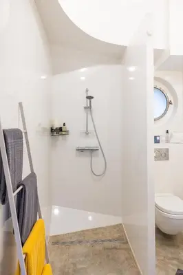 a white bathroom with a shower and a toilet at Boat suite - A Unique Houseboat Stay in Amsterdam in Amsterdam