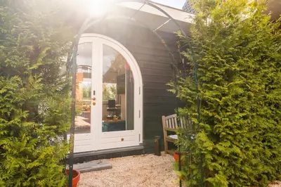 a house with a white door in a yard at The Gentle Arch Schiphol Amsterdam in Aalsmeer