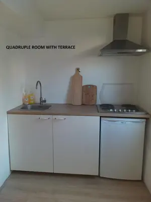 a kitchen with white cabinets and a sink at El Sol Zandvoort 2 in Zandvoort