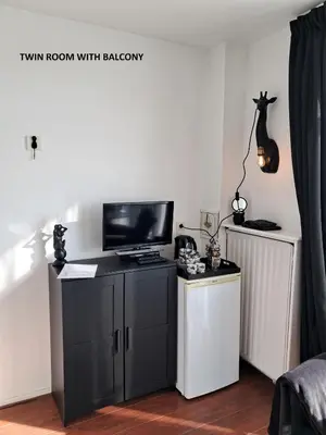 a living room with a tv and a desk with a television at El Sol Zandvoort 2 in Zandvoort