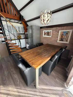 a dining room with a wooden table and leather chairs at Spacious Nature Escape, house for 6 near Amsterdam & Sea in Opmeer