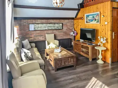 a living room with a couch and a tv at Spacious Nature Escape, house for 6 near Amsterdam & Sea in Opmeer