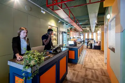 a man and a woman at a counter in an office at Tourist Inn Hotel Amsterdam in Amsterdam