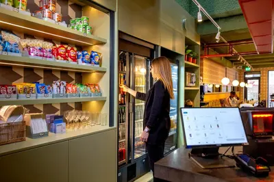 a woman standing in a grocery store buying food at Tourist Inn Hotel Amsterdam in Amsterdam