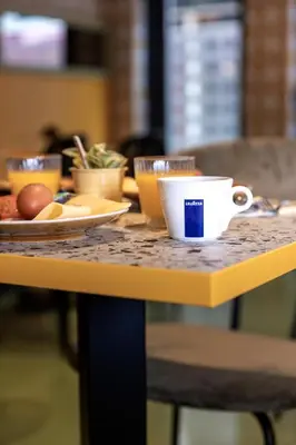 a table with a plate of food and a cup of coffee at Tourist Inn Hotel Amsterdam in Amsterdam