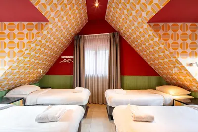 four beds in a room with red and yellow walls at Tourist Inn Hotel Amsterdam in Amsterdam