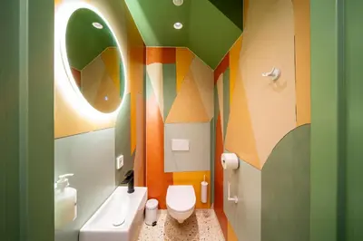 a colorful bathroom with a toilet and a sink at Tourist Inn Hotel Amsterdam in Amsterdam