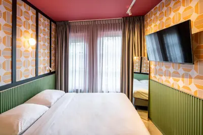 a bedroom with a bed and a flat screen tv at Tourist Inn Hotel Amsterdam in Amsterdam