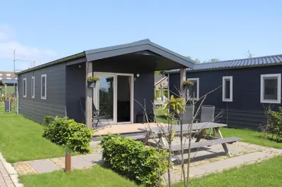 a blue house with a picnic table in front of it at Chalet 4, Recreatie aan de Vecht in Weesp