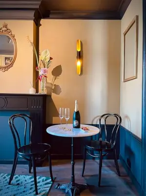 a table with two chairs and a bottle of wine at City Apartment With Canalview at Canalhouse-Majestic in Utrecht
