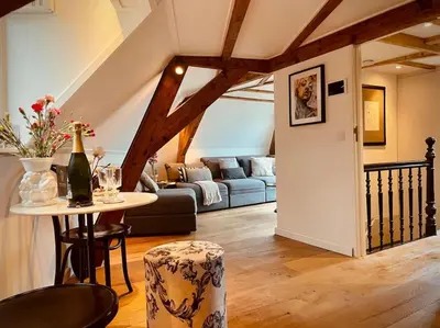 a living room with a couch and a table at Cosy Penthouse with Rooftop Canalhouse-Majestic in Utrecht