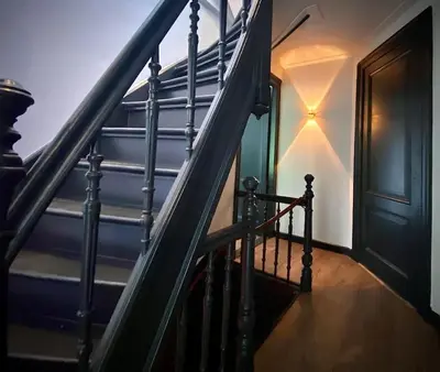 a staircase in a house with a black door at Cosy Penthouse with Rooftop Canalhouse-Majestic in Utrecht