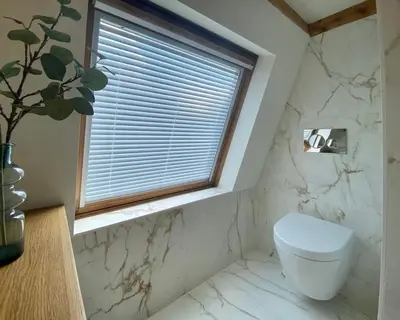 a bathroom with a white toilet and a window at Cosy Penthouse with Rooftop Canalhouse-Majestic in Utrecht