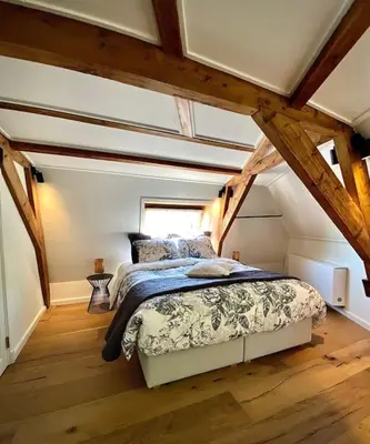 a bedroom with a bed in an attic at Cosy Penthouse with Rooftop Canalhouse-Majestic in Utrecht