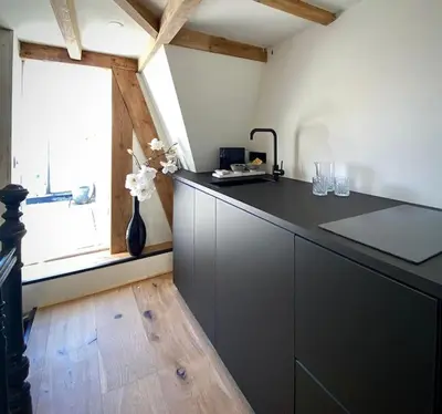 a kitchen with a black counter top and a window at Cosy Penthouse with Rooftop Canalhouse-Majestic in Utrecht