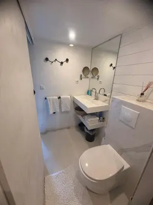 a white bathroom with a toilet and a sink at R&M Boutique in Lijnden