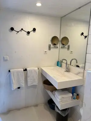 a bathroom with a sink and a mirror and towels at R&M Boutique in Lijnden