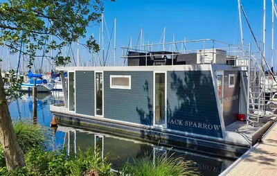 a tiny house on a boat in the water at Blackbeard in Almere