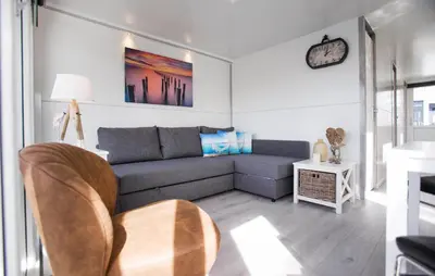 a living room with a couch and a clock on the wall at Blackbeard in Almere