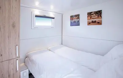 a small bedroom with two beds and a window at Barbossa in Almere