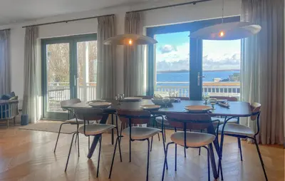 a dining room with a table and chairs and a large window at Beautiful Home In Loosdrecht With Wifi in Loosdrecht