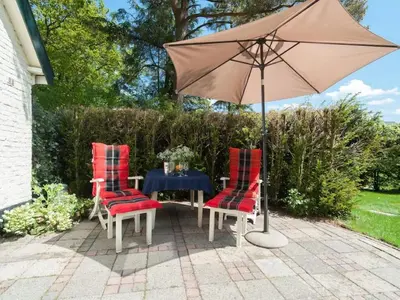 a table with two chairs and an umbrella at Kleine Nachtegaal in Schoorl