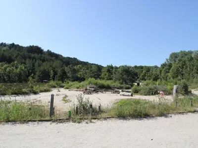 a beach with a person riding a bike on the sand at Kleine Nachtegaal in Schoorl