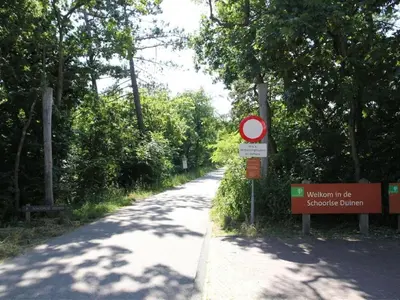 a sign on the side of a road with trees at Kleine Nachtegaal in Schoorl
