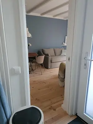 a living room with a couch and a table at Cottage at Sea in Noordwijk aan Zee