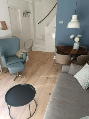 a living room with a couch and a table at Cottage at Sea in Noordwijk aan Zee